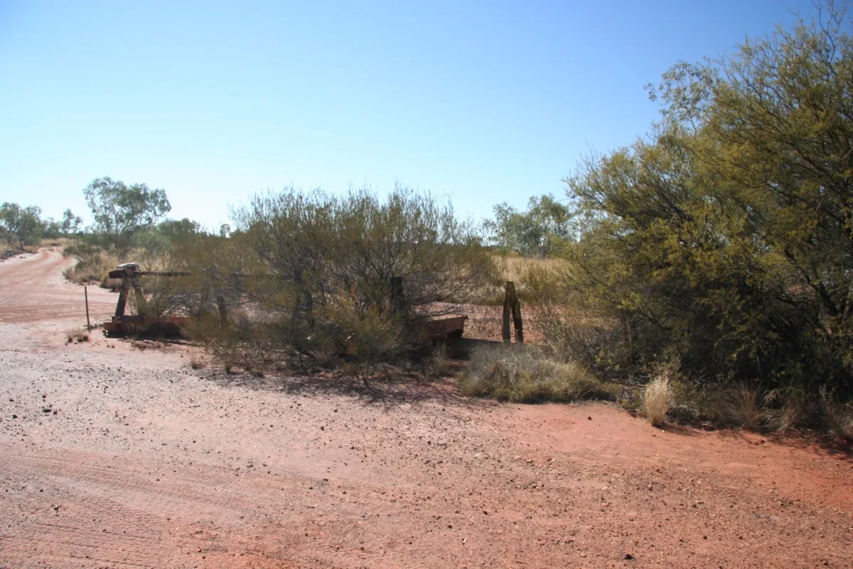 Remote outback track through sparse desert scrubland