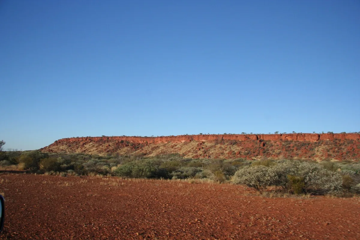 Red mesa formation towers over the Australian outback