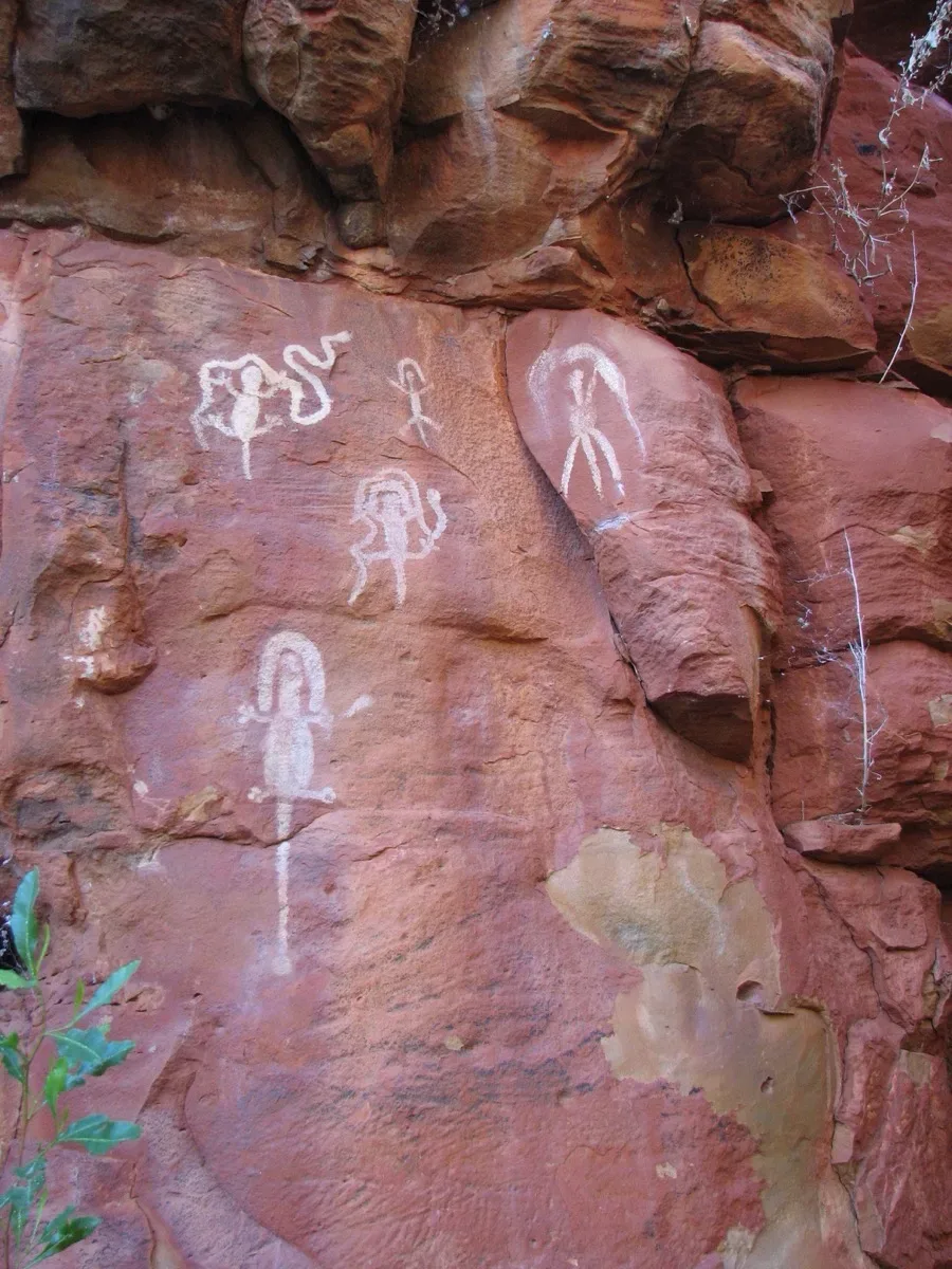 Multiple Aboriginal figures create an ancient art gallery on stone