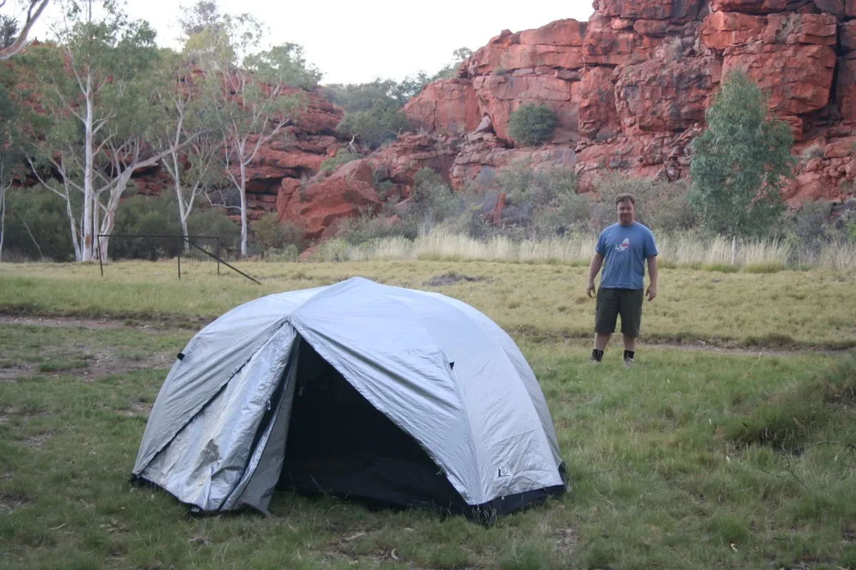 Bush camping beneath ancient red cliffs in outback Australia