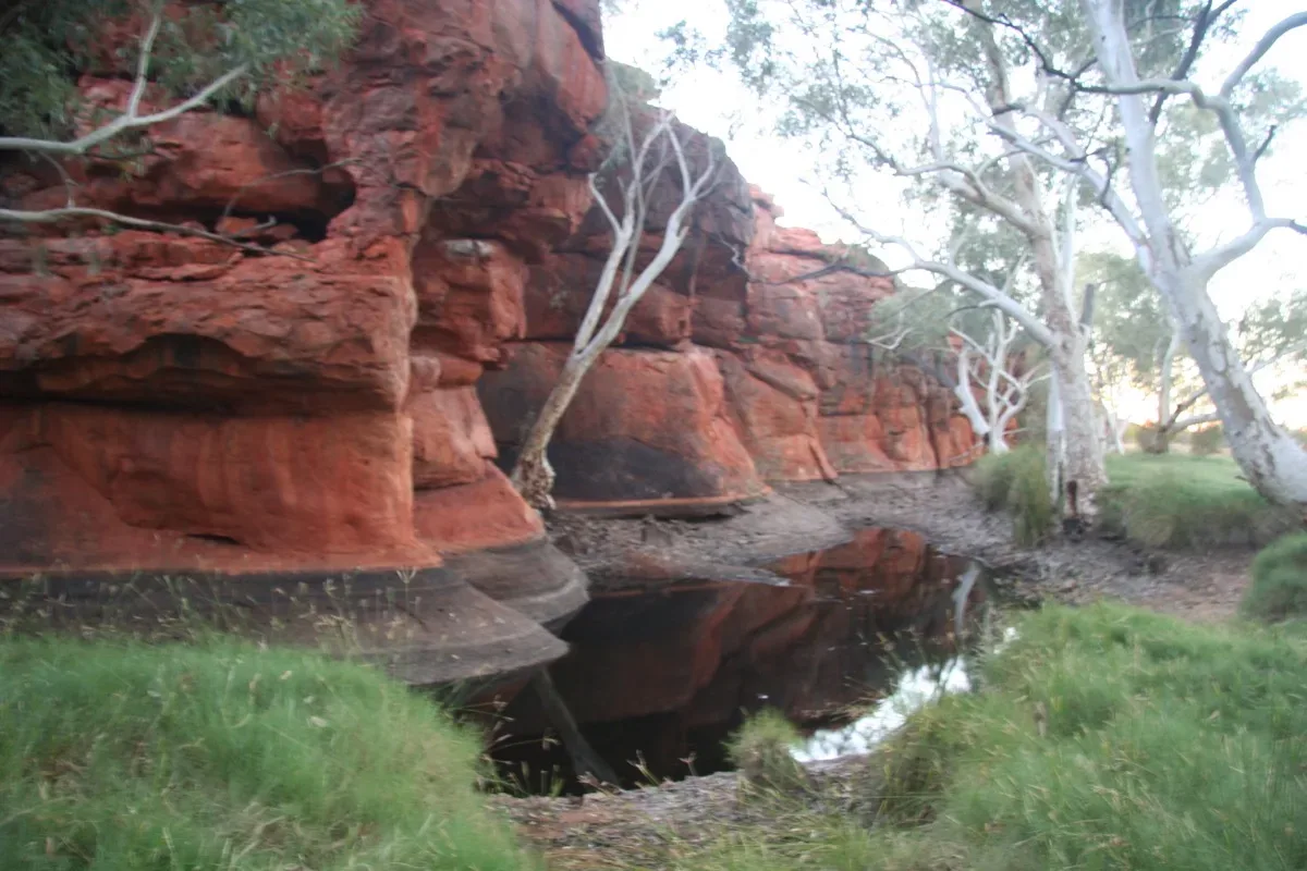 Natural waterhole carved into ancient red rock formations