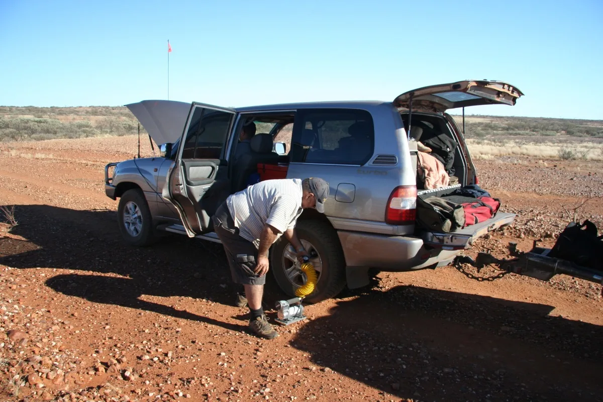 Outback tire change under clear blue desert skies