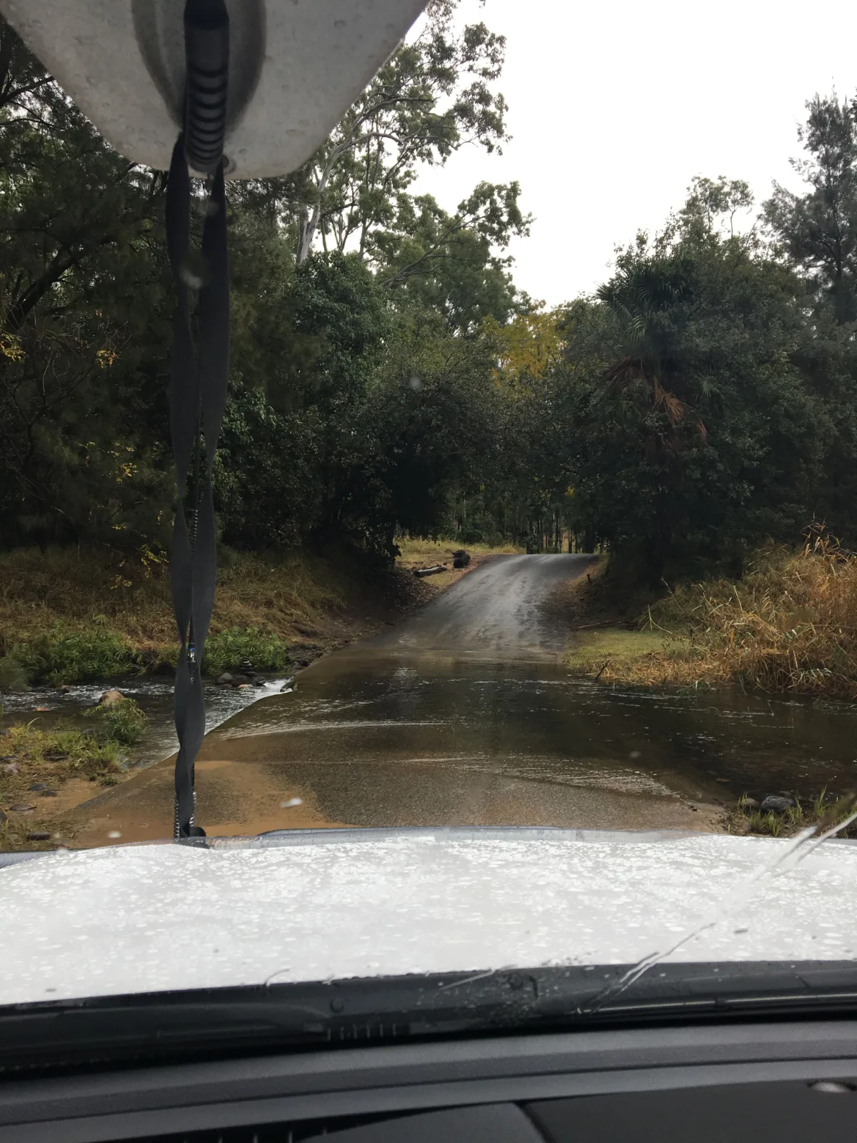A flooded creek crossing after persistent rain.