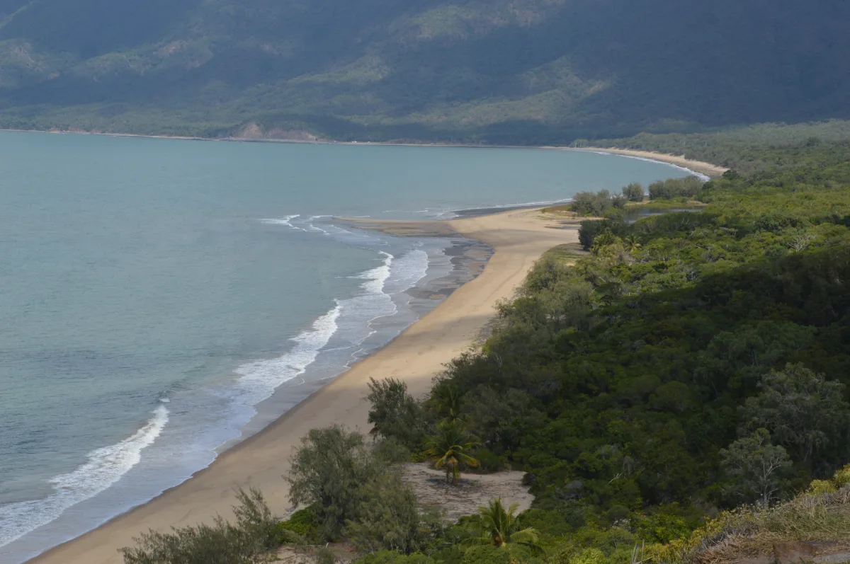 A stunning view of the coastline north of Port Douglas, showcasing the dramatic meeting of rainforest and reef.