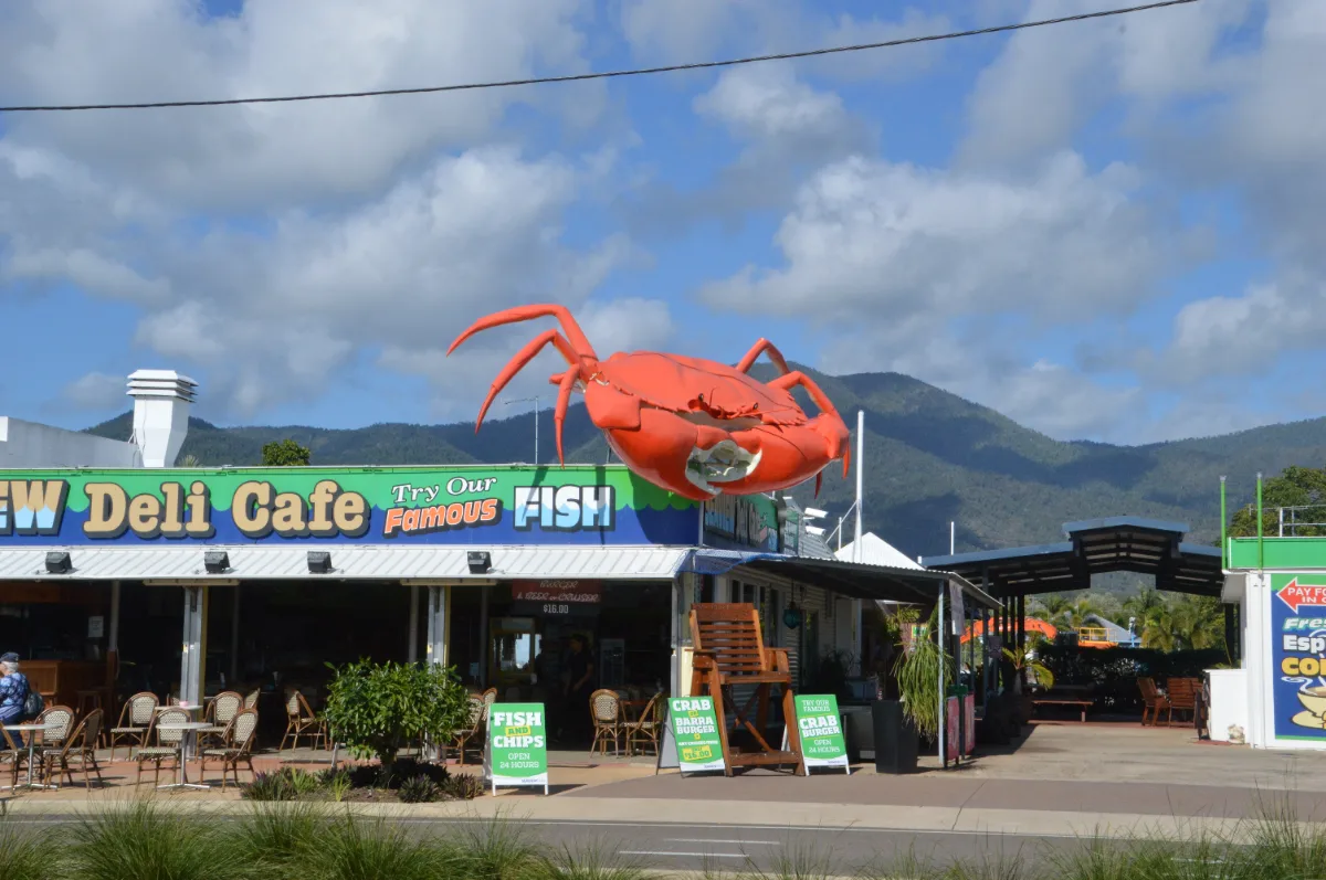 A larger-than-life crab sculpture perched atop a local restaurant, a whimsical landmark in Cardwell.