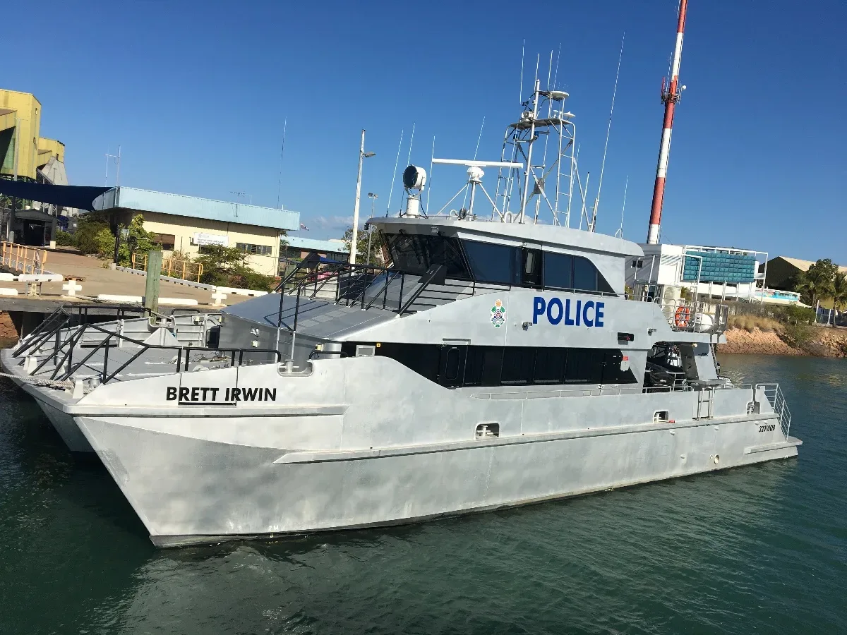 A stern-looking water police vessel moored in the harbour.