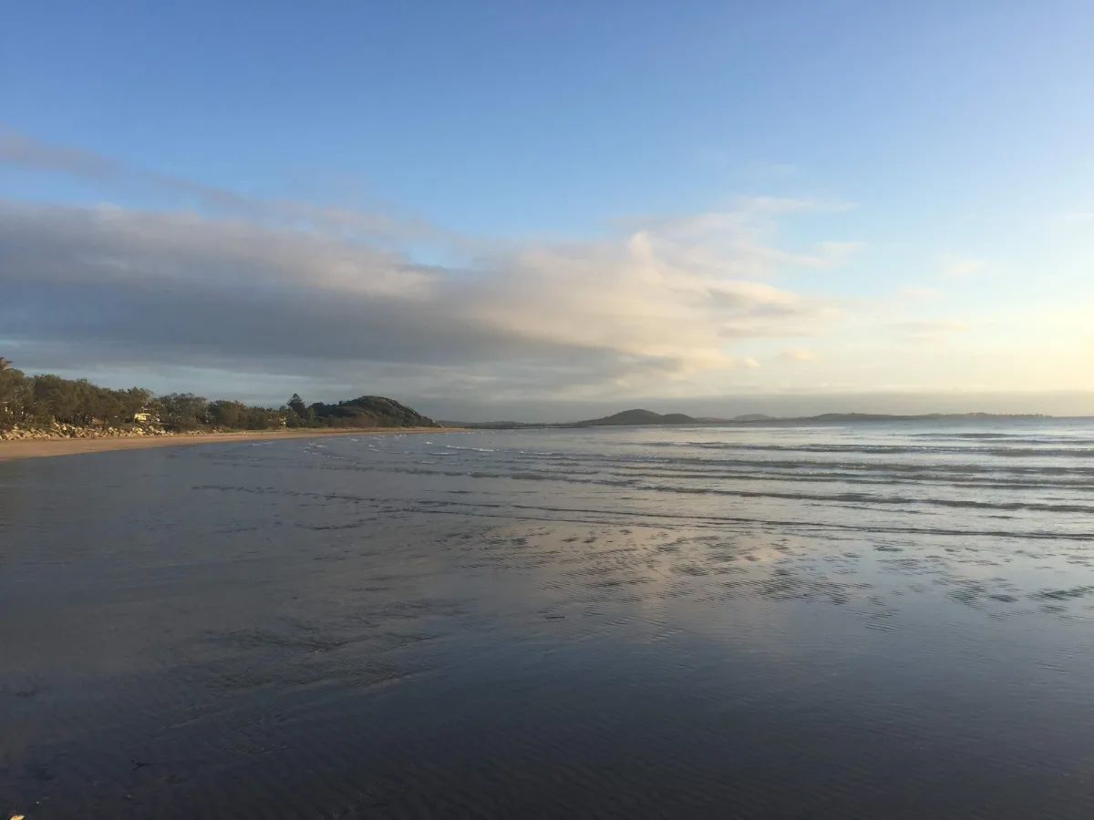 The tide recedes to reveal a tranquil beach.