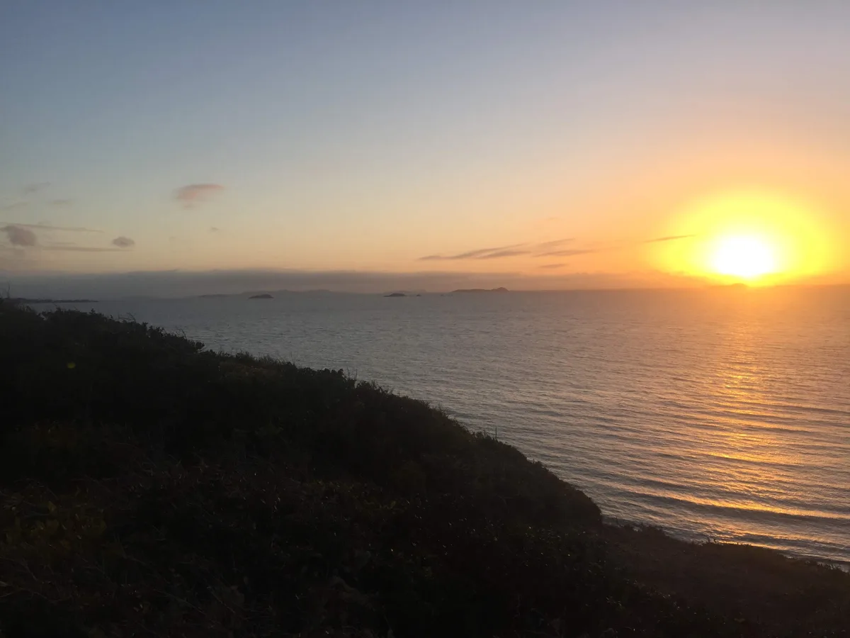 The sun dips below the horizon, casting a golden glow over the ocean at Keppel Sands.