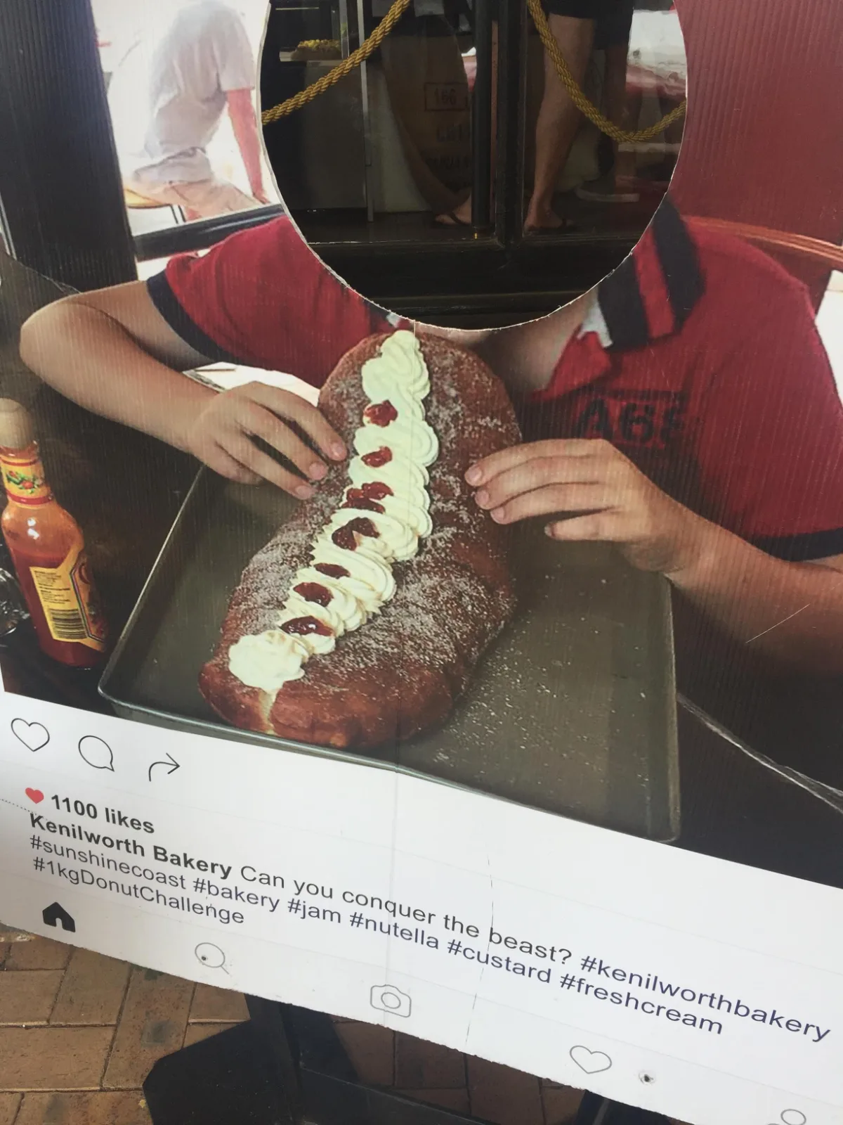 A person stands behind the Kenilworth Bakery's giant doughnut cutout.