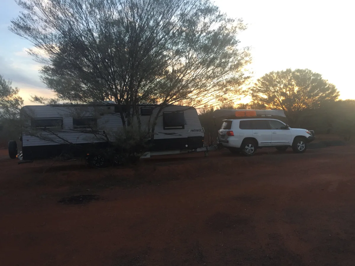Our home on wheels parked amongst the desert scrub near Bourke, illuminated by the setting sun.