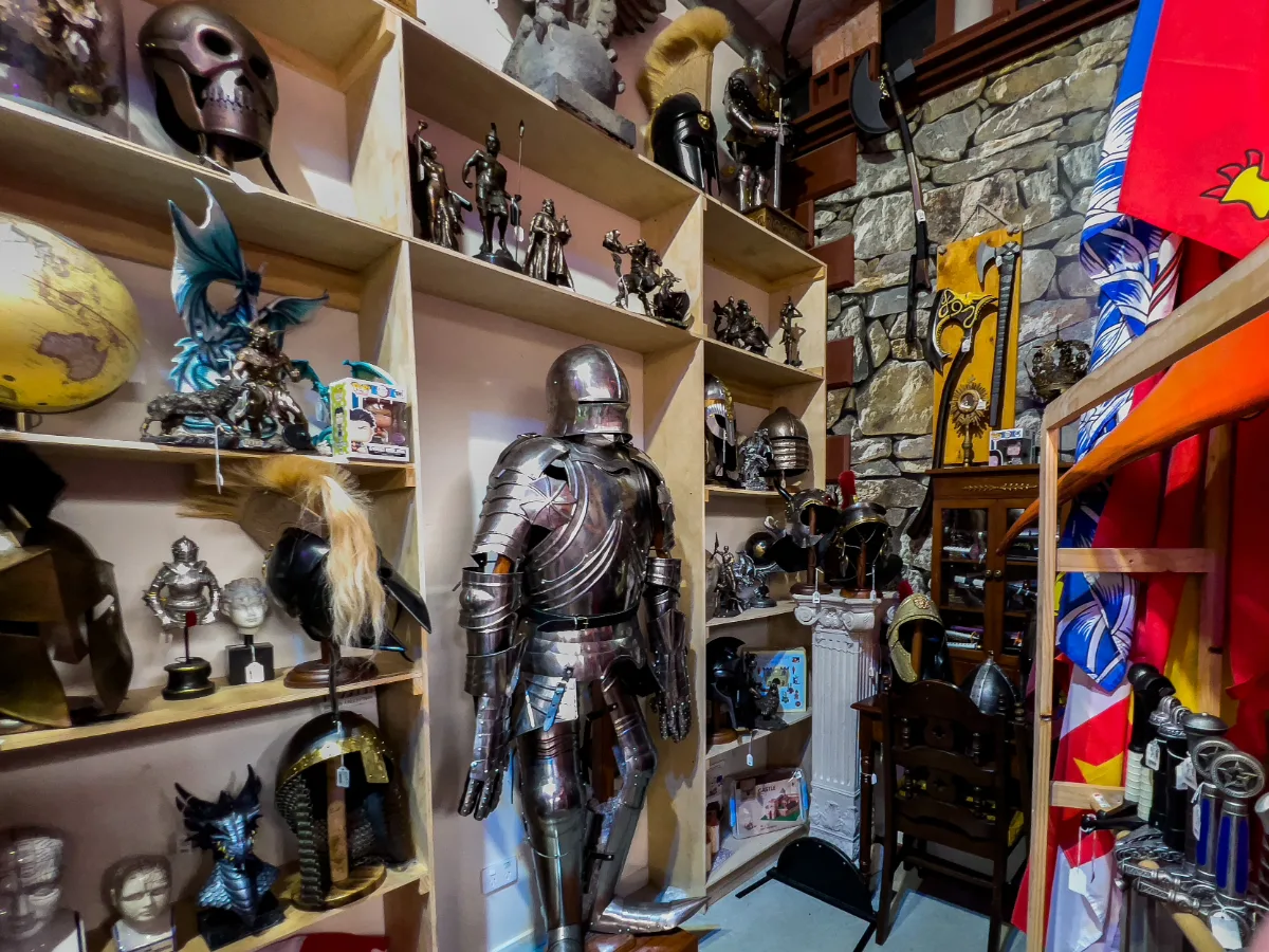 A full suit of armour, standing guard amidst shelves of historical artefacts.