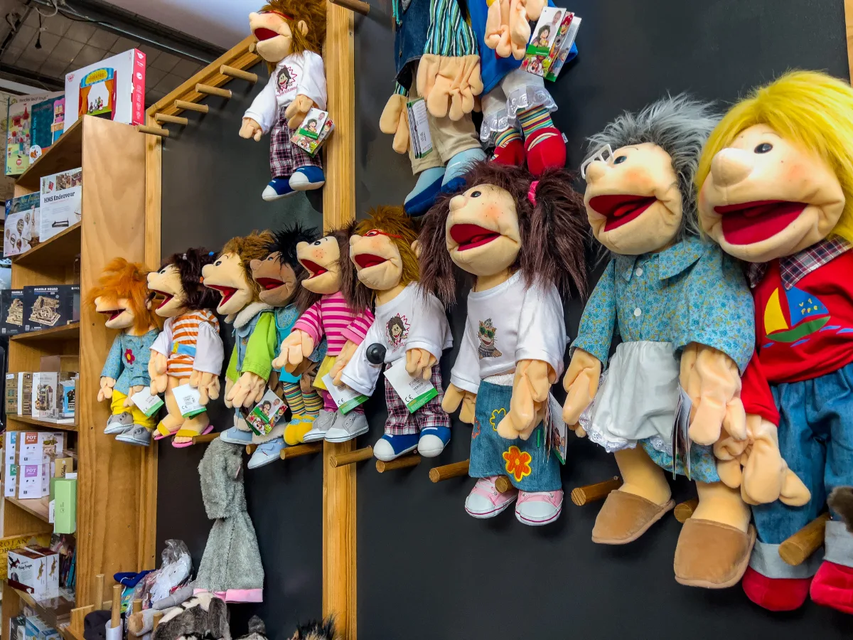A collection of handcrafted puppets line the wall, each with its own unique personality.