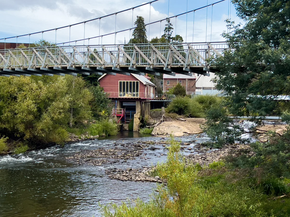 A pedestrian bridge over the Meander River, offering scenic views of the town.