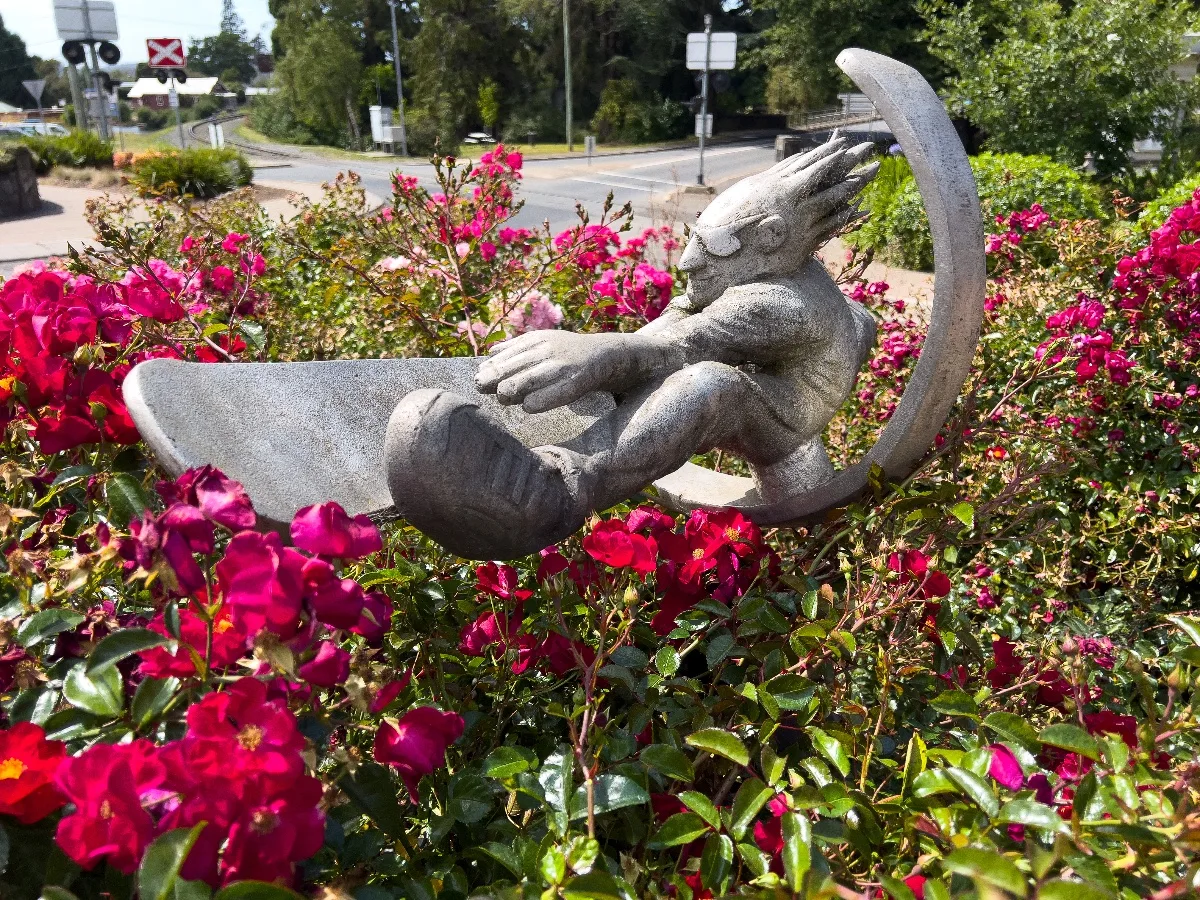 A surreal sculpture amidst a vibrant bed of flowers, adding to Deloraine's artistic charm.
