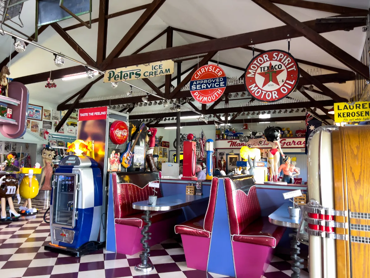 The interior of the diner is filled with authentic vintage signs and retro vinyl booths.