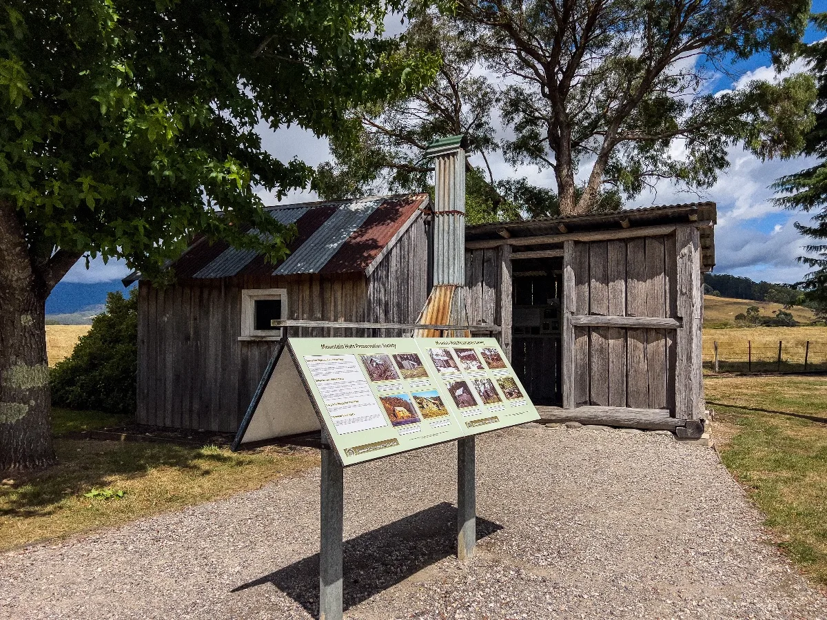An old vertical-slab pioneer cottage preserved in town with an informative display about early settlement.