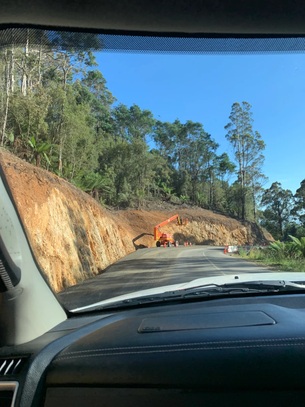 The narrow and winding Tasman Highway, where the roadworks are tucked right into the steep orange cliffs.