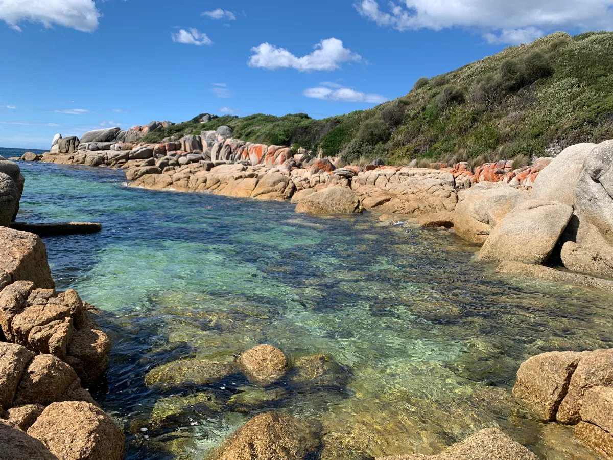 The crystal-clear water and those iconic orange-covered rocks near our new campsite.
