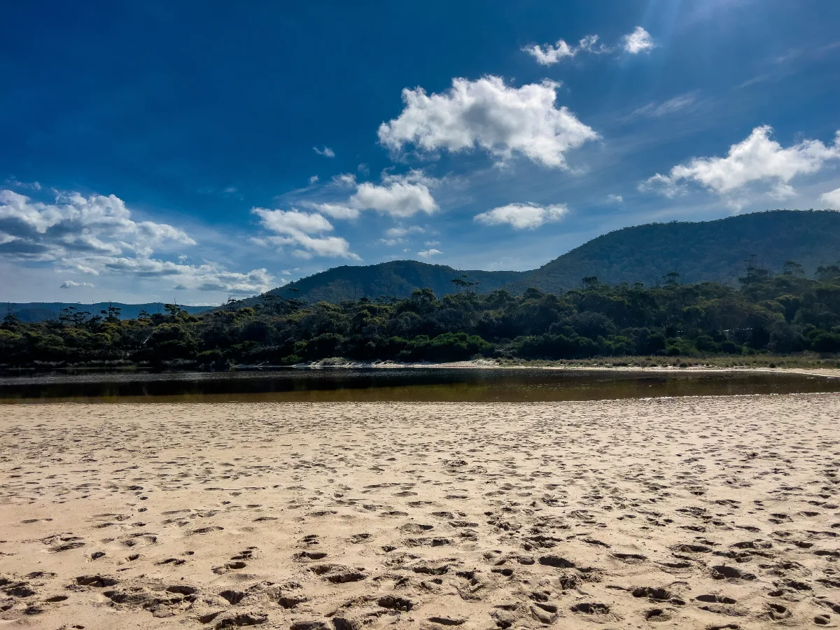 A perfect afternoon at the lagoon where the calm water meets the sand, with the mountains of the national park standing tall in the background.