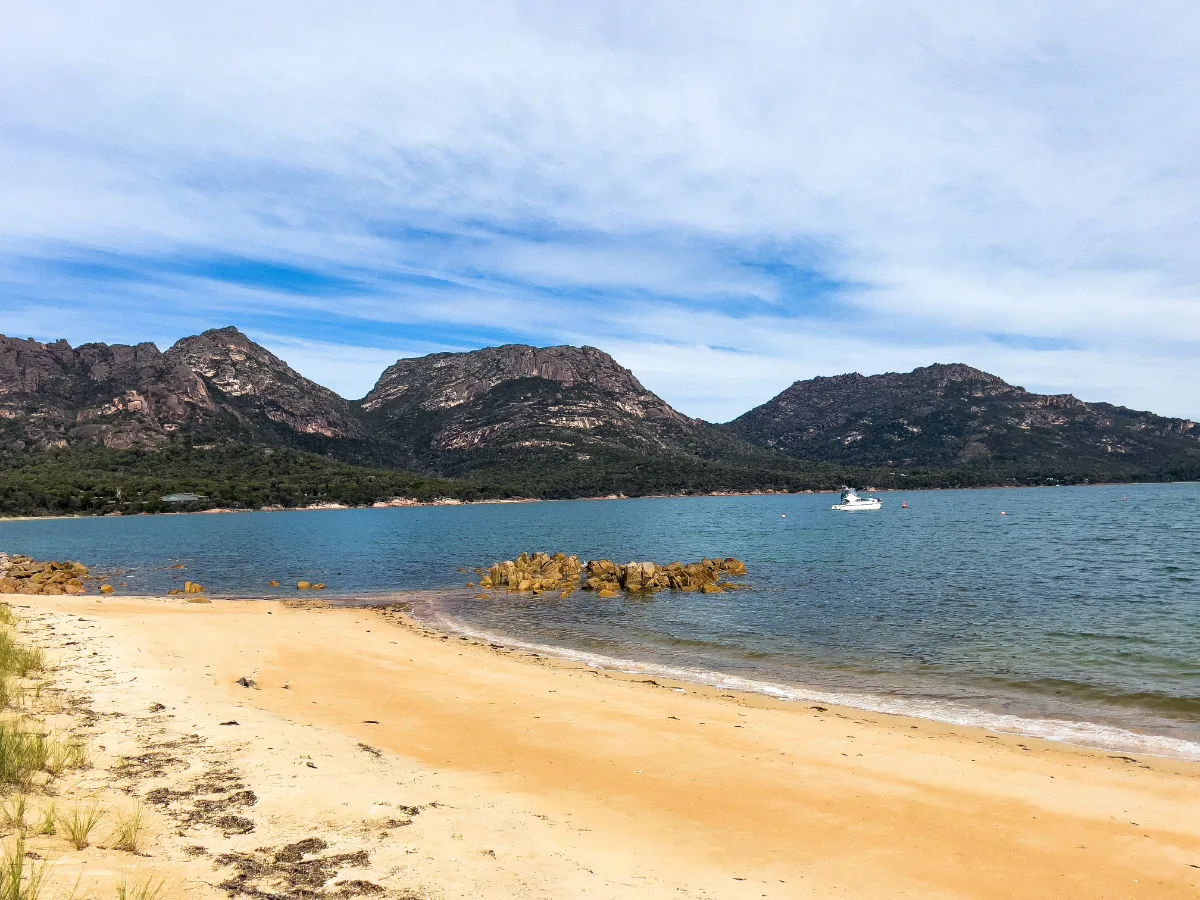 The impressive granite peaks of the Hazards towering over the white sands of the bay.
