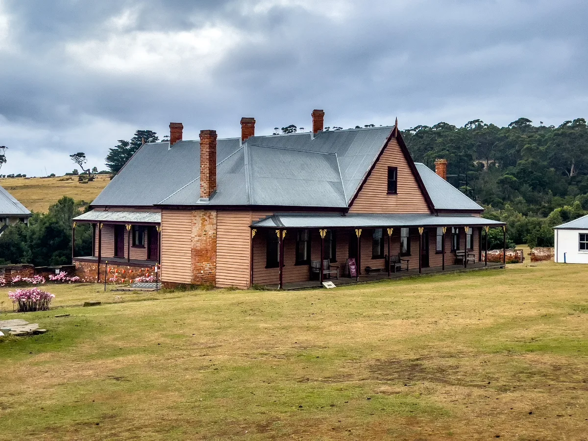 The main settlement building at Darlington stands tall against the grey Tasmanian sky, looking much the same as it did a century ago.