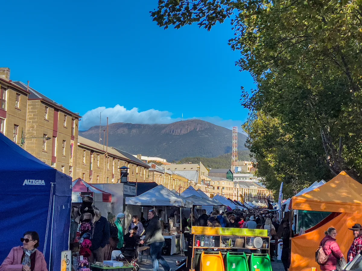 Salamanca Markets in full swing with the mountain watching over the stalls and the historic sandstone buildings.
