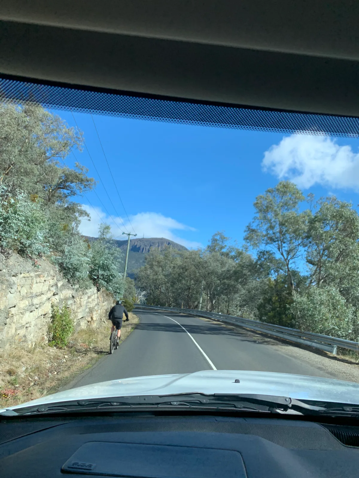 Following a very brave cyclist on the long, winding road up toward the summit.