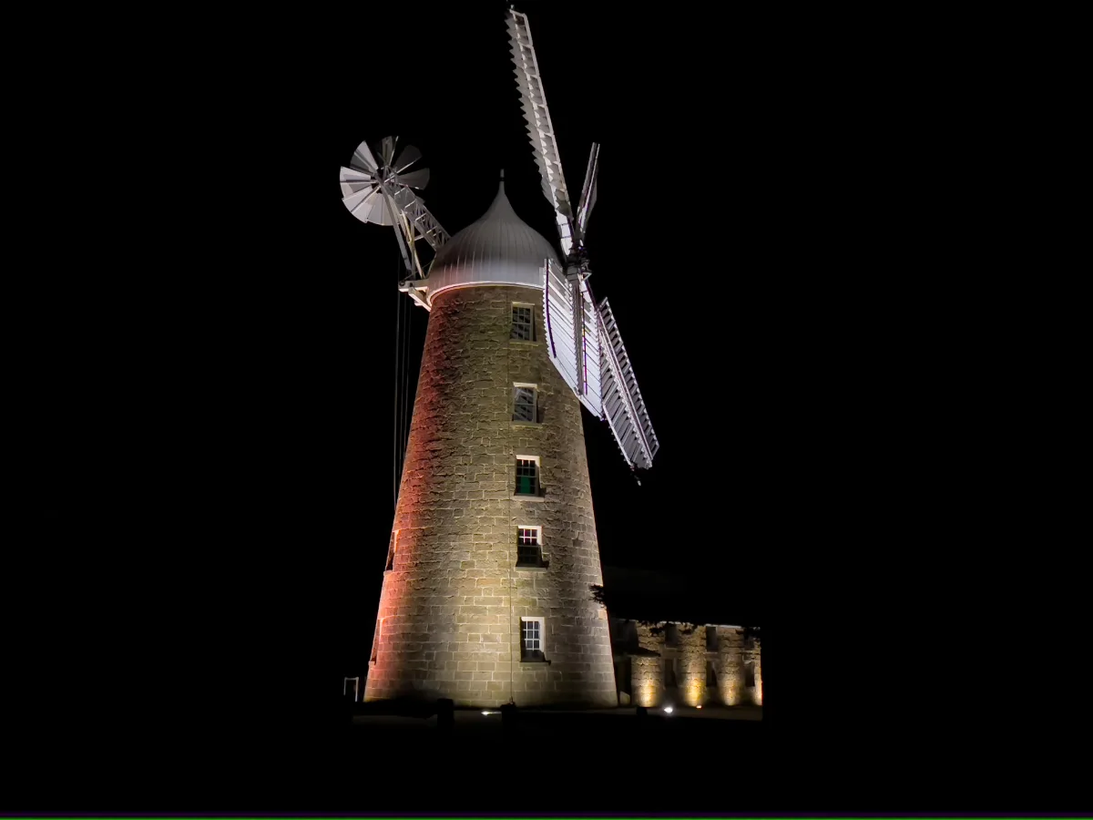 The great windmill at Callington Mill illuminated brilliantly against the night sky.