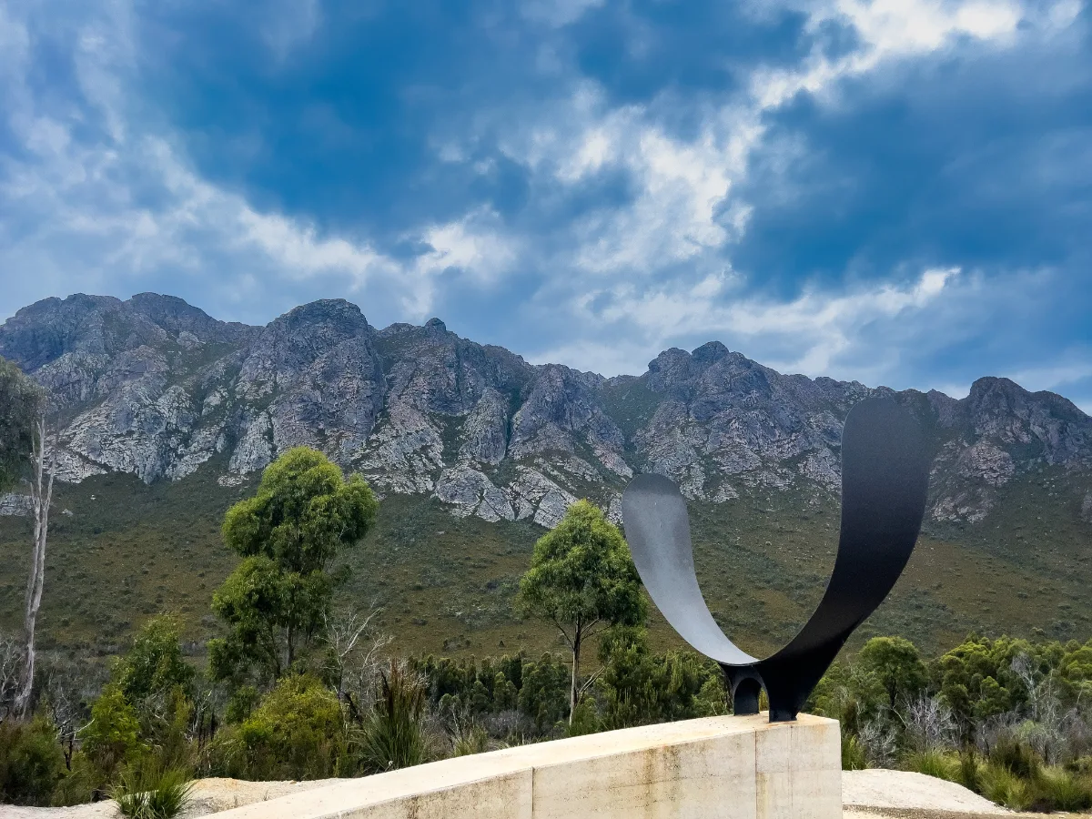 The 'Bitumen Bones' sculpture standing tall against the rugged backdrop of the Southwest mountains.