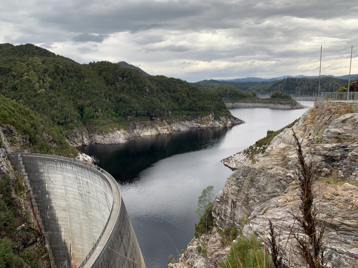 The massive curve of the Gordon Dam wall holding back the deep waters of Lake Gordon.