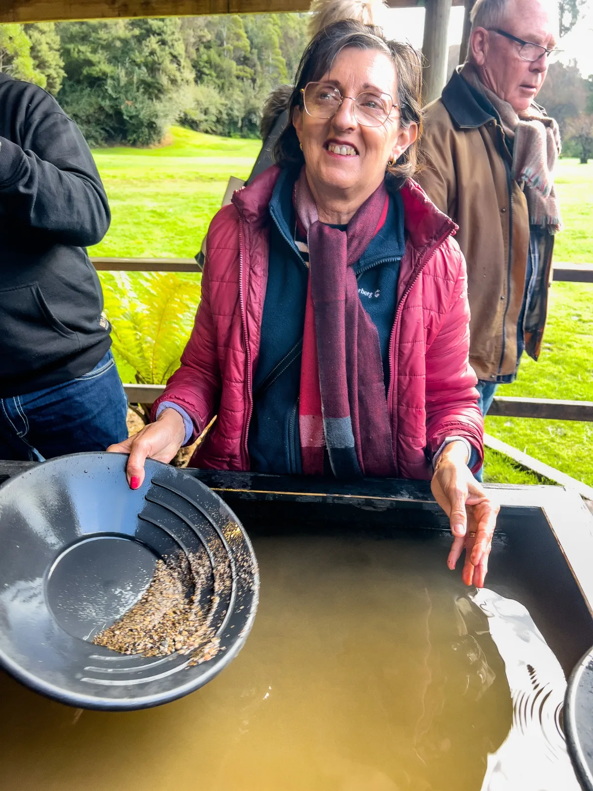 Lisa showing off her technique and a few specks of gold after a bit of panning in the muddy water.