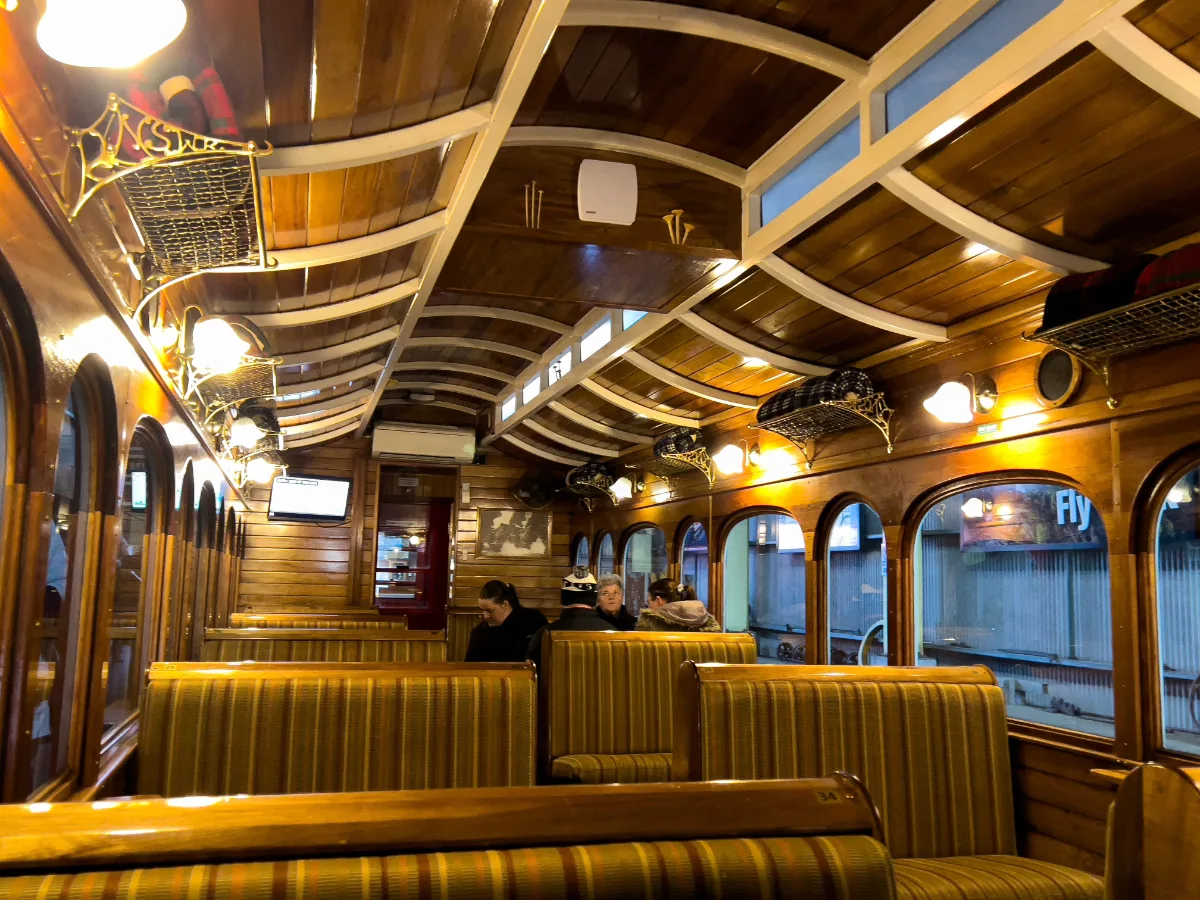 The interior of the railway carriage is stunning, featuring beautifully polished timber ceilings and warm, inviting lighting.