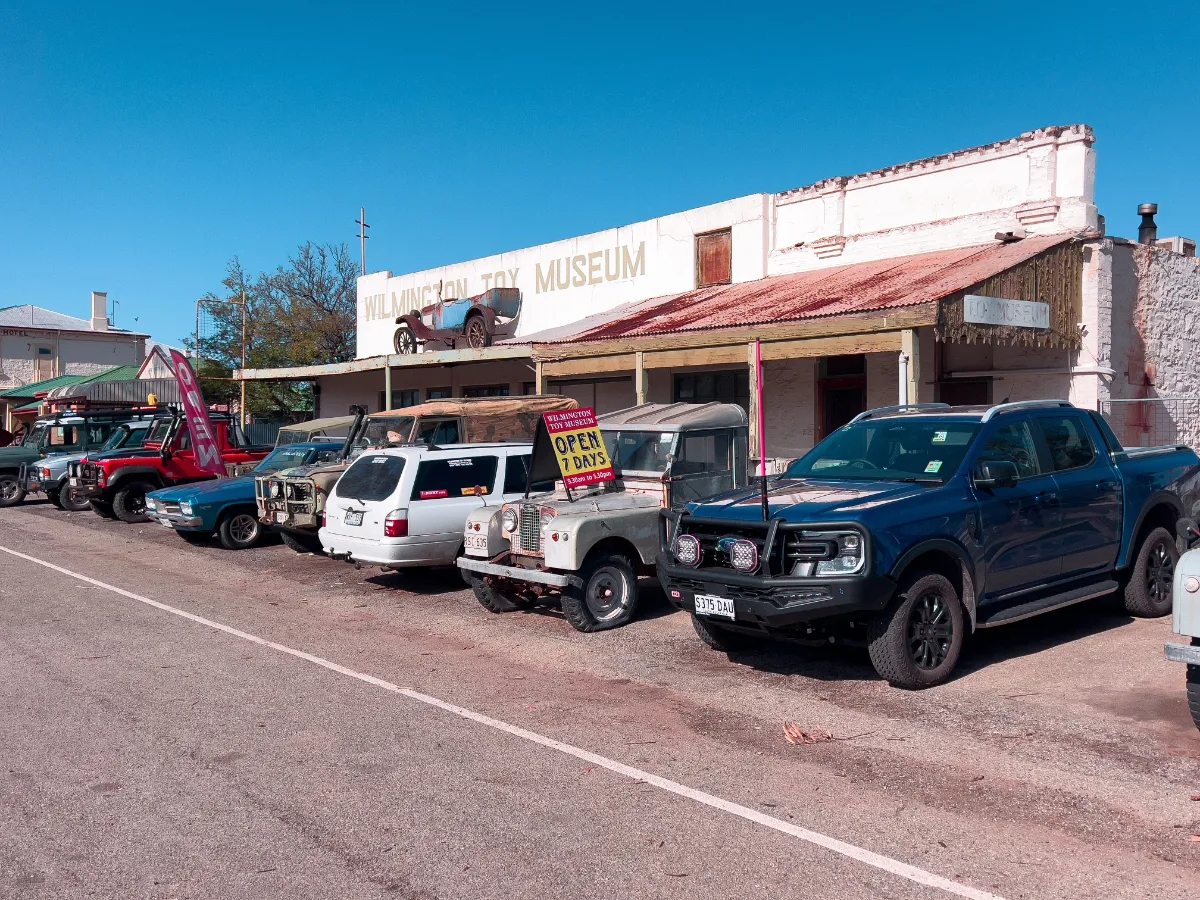 The Wilmington Toy Museum, with its quirky rooftop display and a row of parked vehicles.