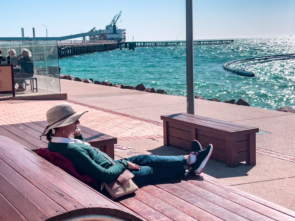 Lisa enjoys a moment of peace on a bench in Wallaroo, battling the strong winds.