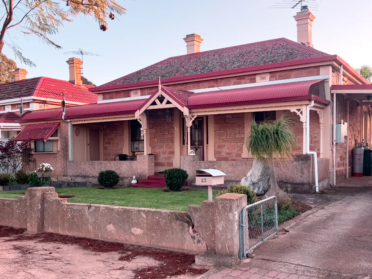 This house, like many in Hamley Bridge, features vibrant pops of red that enhance its historical charm.