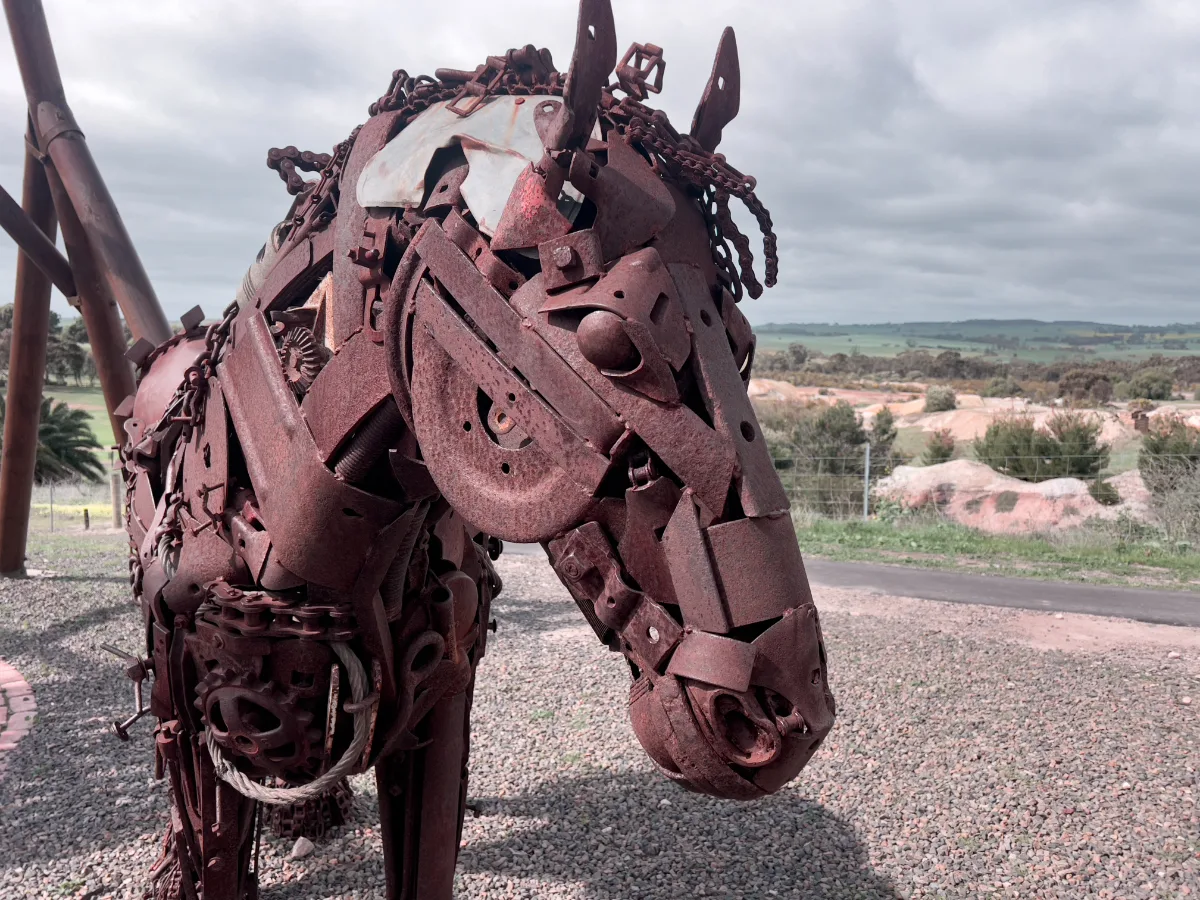 This horse sculpture, pieced together from scraps of mining equipment, serves as a silent sentinel, its rusted frame embodying the passage of time and the enduring spirit of Kapunda's mining history.