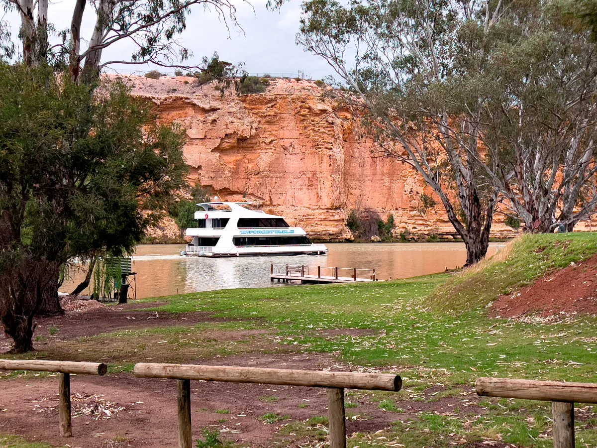 River cliffs tower over a modern cruise boat on the Murray River near Mannum.