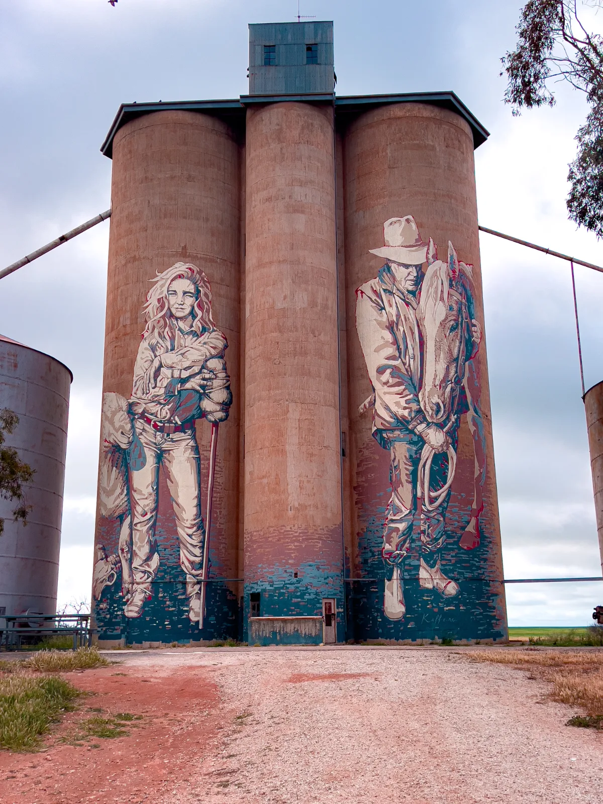 Kaff-eine's striking mural on the GrainCorp silos at Rosebery features a contemporary horseman and a young female farmer, capturing the essence of the Wimmera region.