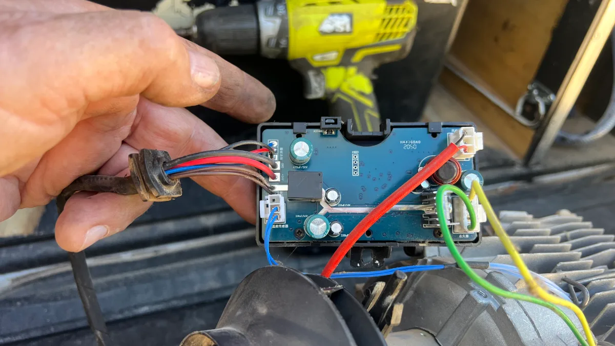 A delicate operation: delving into the inner workings of the diesel heater control board. Apparently, red wires are important.