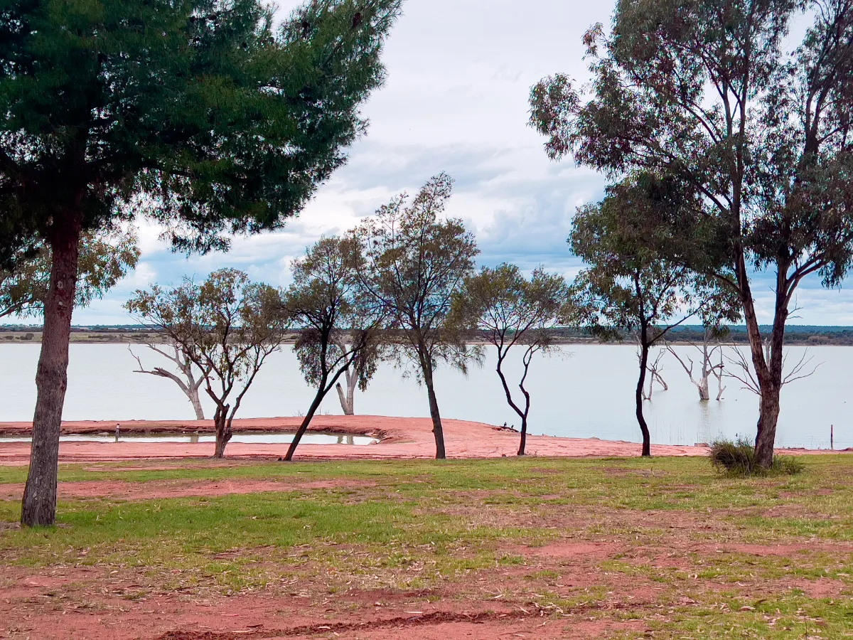 The still water of Lake Wyangan reflects the surrounding foliage, creating a mirrored world of calm.