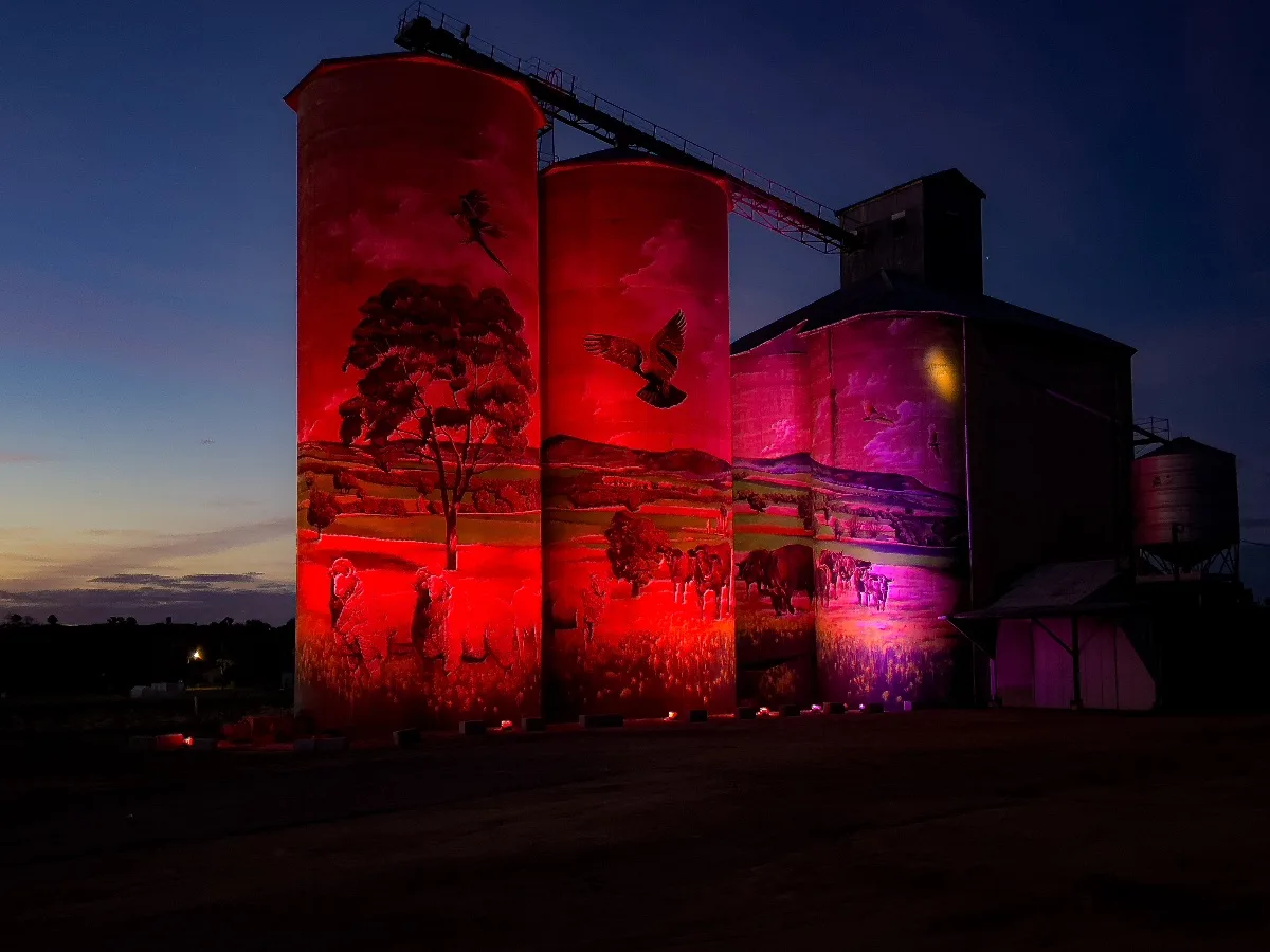 The Grenfell silos illuminated in a striking red hue, transforming the familiar artwork into something dramatic.