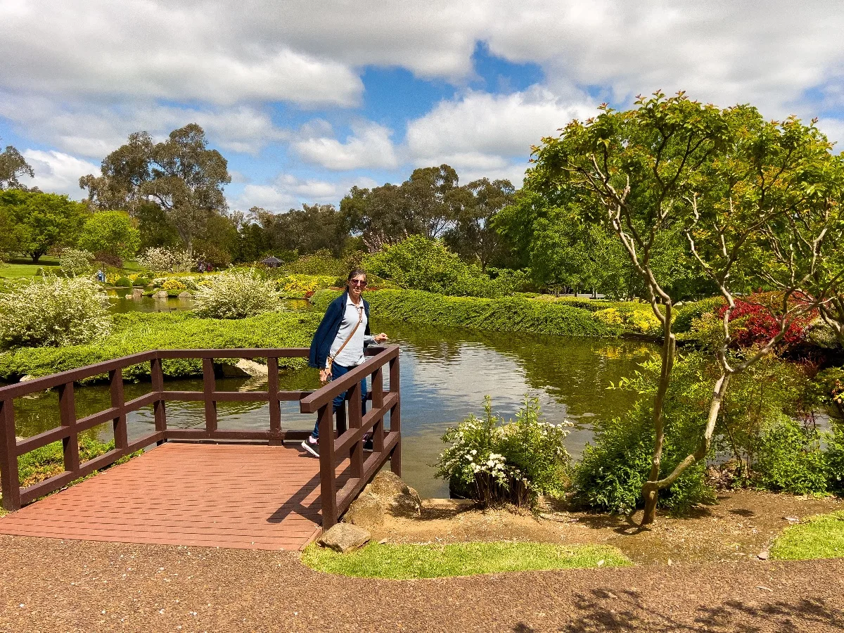 Lisa takes a moment to enjoy the peaceful setting from a small bridge over a pond within the gardens.