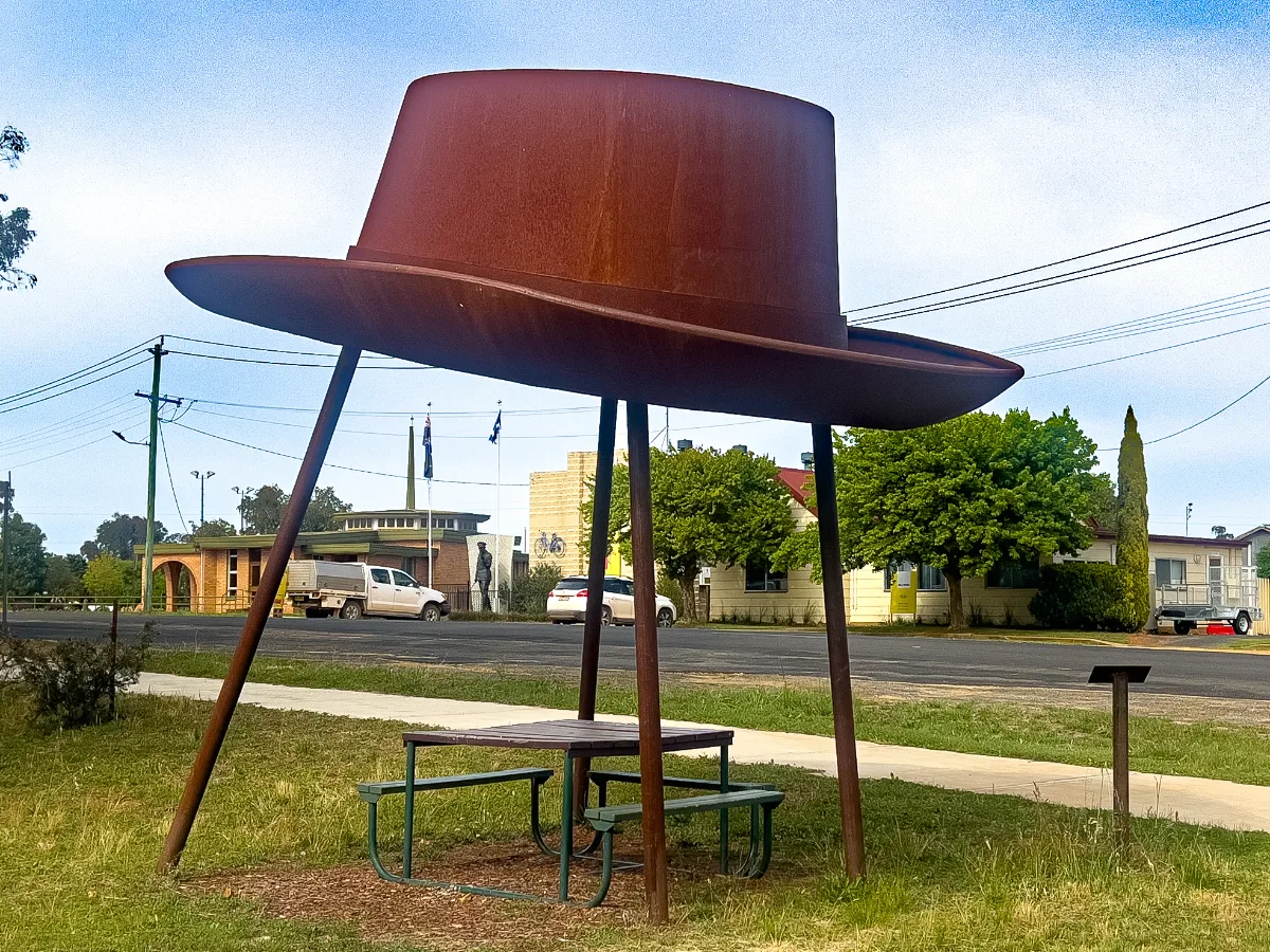 A whimsical tribute to Banjo Paterson: an oversized metal hat providing shade and a unique photo opportunity in Yeoval.