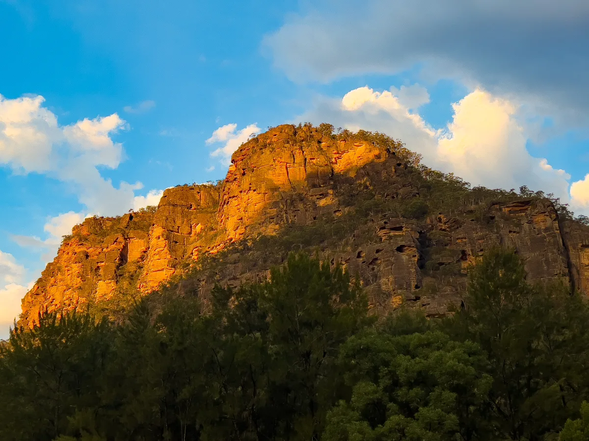 The cliffs of Glen Davis illuminated by the warm glow of the setting sun.