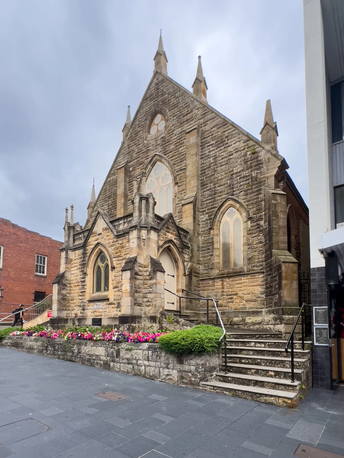 An example of the architectural contrast in Wollongong: An old stone church stands in the city centre