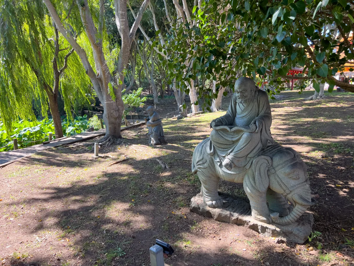 Stone figures populate the peaceful temple gardens.