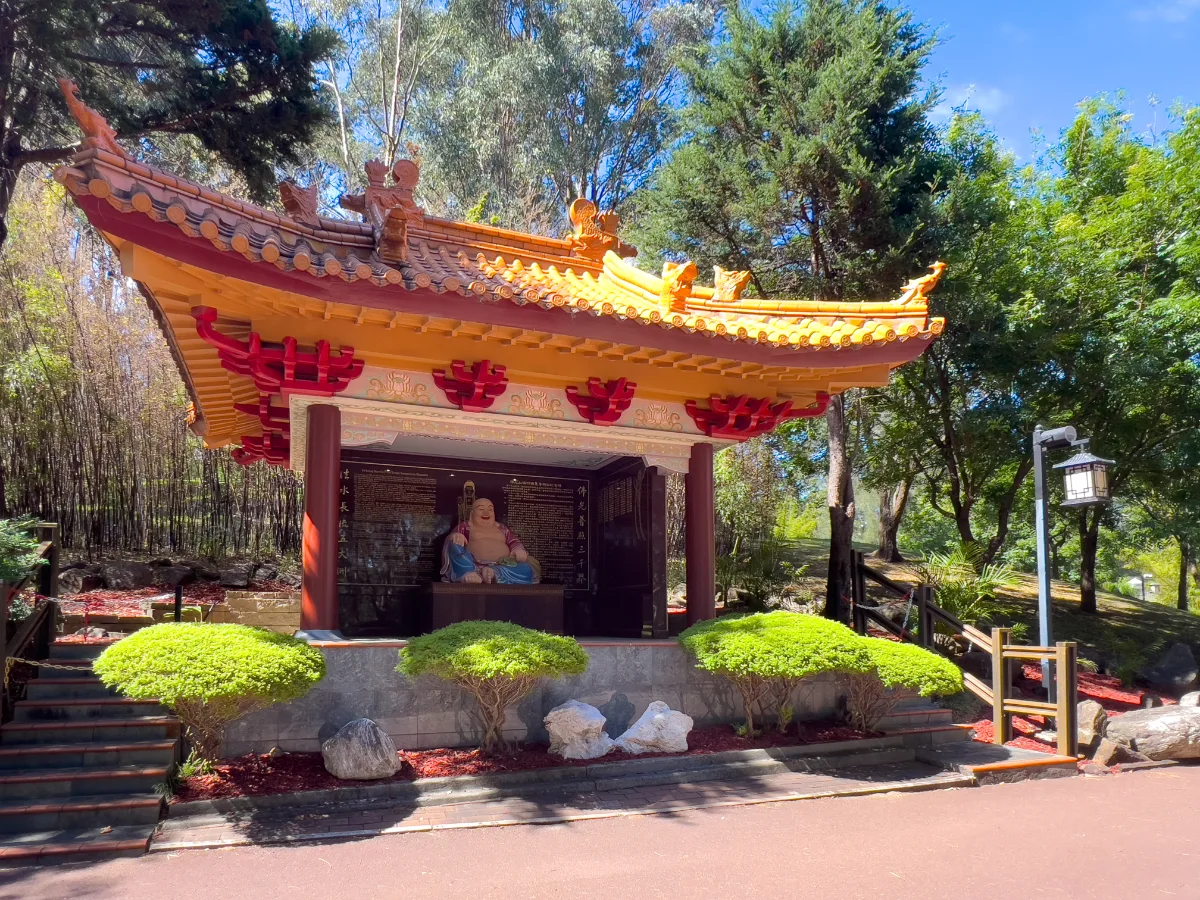A peaceful deity resides in a charming garden shrine.