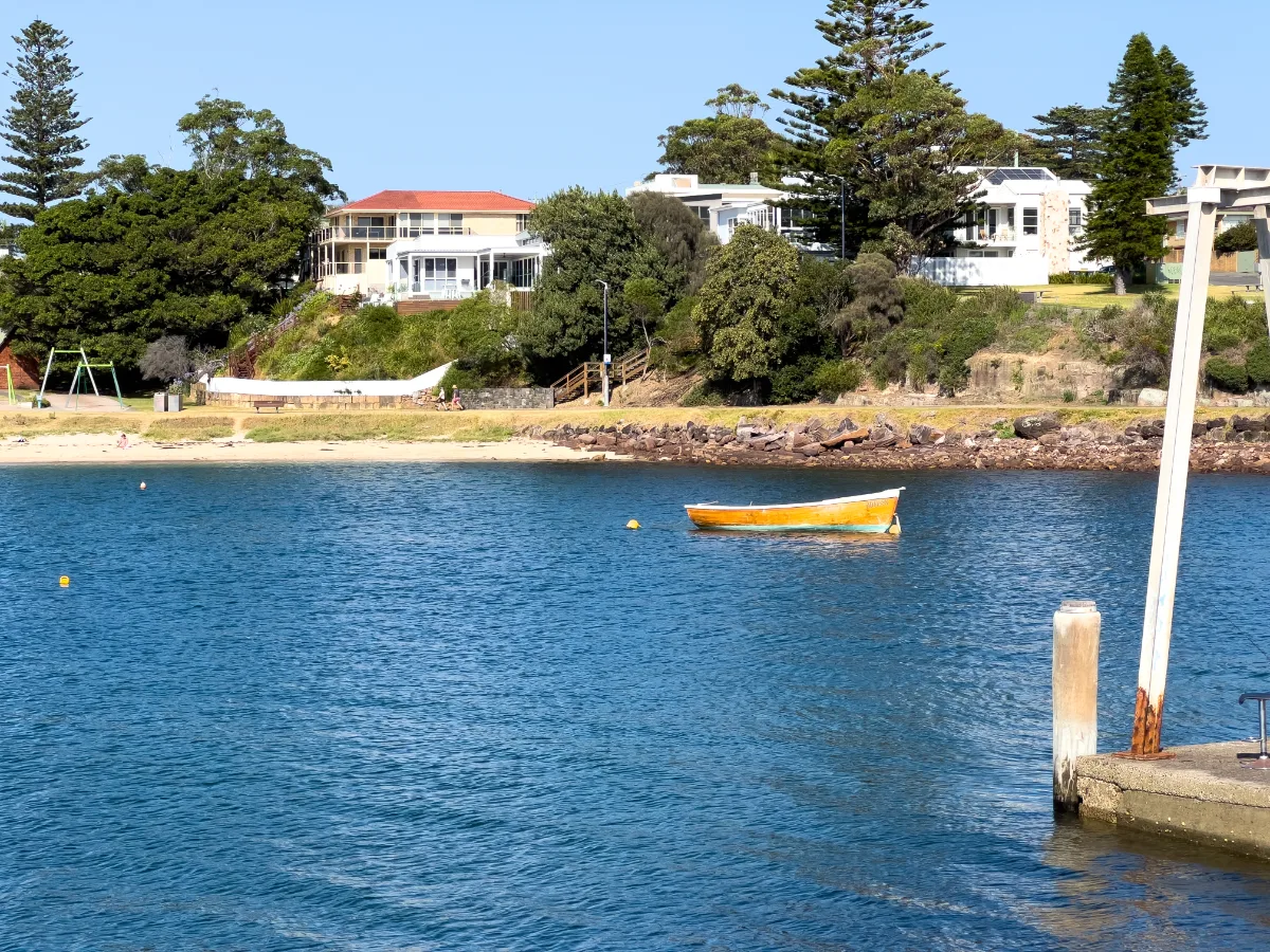 A close-up of the waterside, highlighting the pristine waters and the residences perched above the shore in Shellharbour.