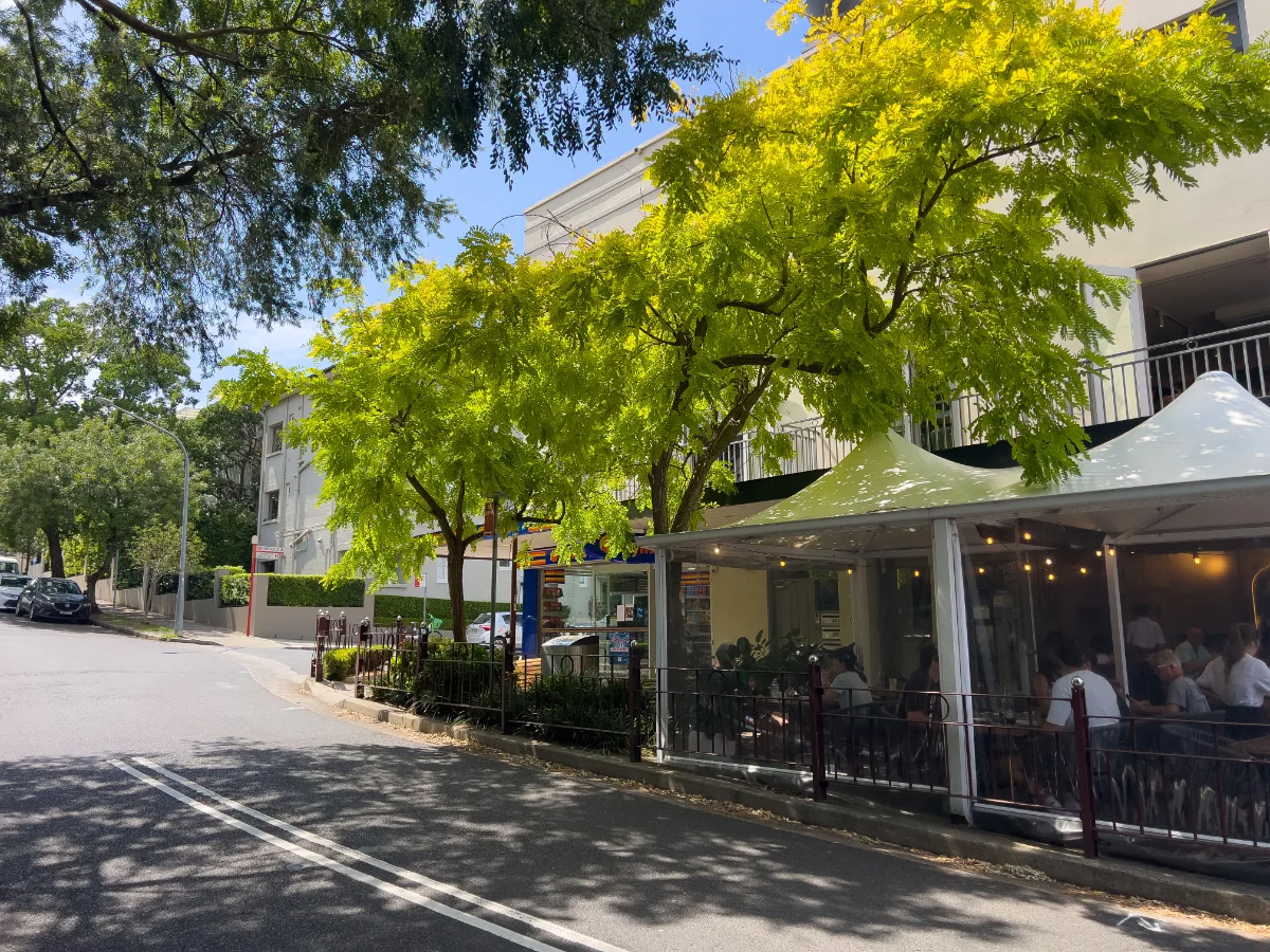 A charming street scene near Kirribilli, with a café bustling with patrons.