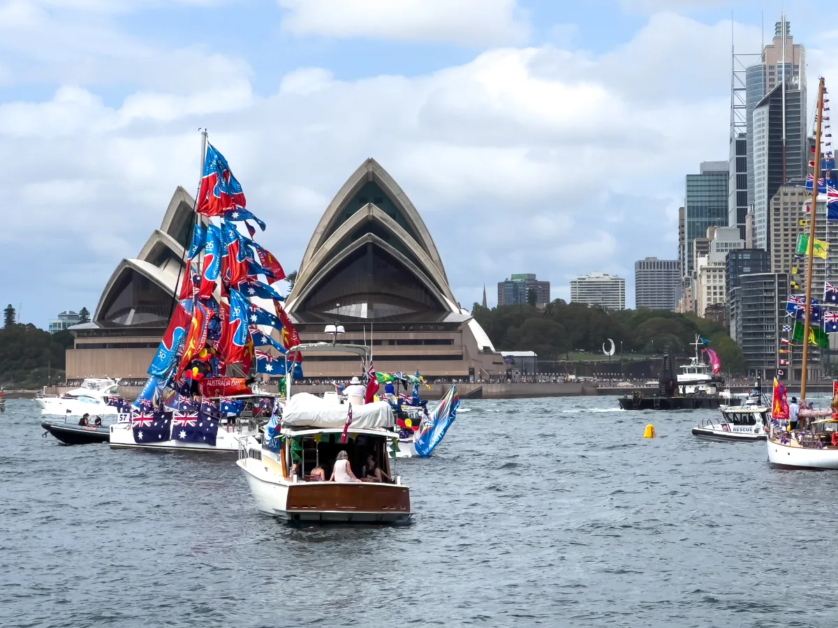 A colourful flotilla of boats adorned in Australian flags near the Opera House.
